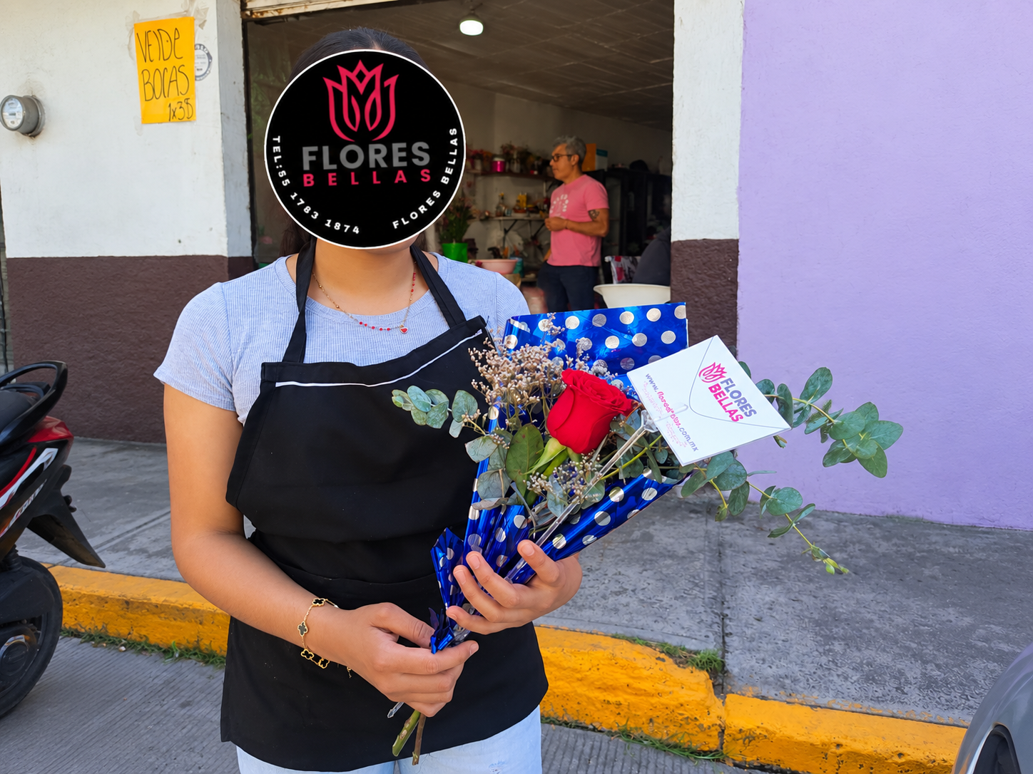 Entrega de rosa roja en envoltura azul de Flores Bellas