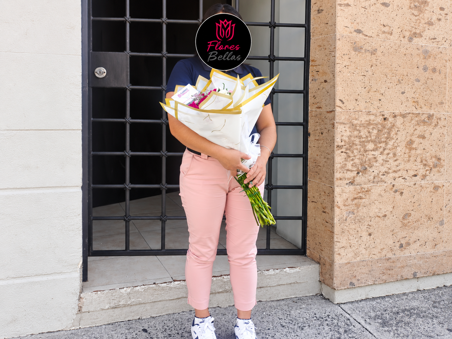 Entrega de ramo envuelto en papel blanco y dorado de Flores Bellas